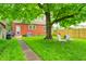 Backyard scene featuring a large tree, patio chairs, manicured lawn, and access to the house at 752 N Leland Ave, Indianapolis, IN 46219