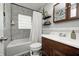 Bright bathroom features gray tile surround, a shower-tub combo, a dark wood vanity, and built-in shelving at 752 N Leland Ave, Indianapolis, IN 46219
