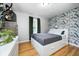 Bright bedroom features a full-size bed, wall-mounted television, green curtains, and a charming floral wallpaper accent wall at 752 N Leland Ave, Indianapolis, IN 46219