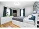 Well-lit bedroom with stylish floral wallpaper, a full-size bed with storage, and windows with lush green curtains at 752 N Leland Ave, Indianapolis, IN 46219