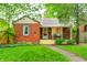 Charming brick home with a manicured front lawn, mature trees, and a cozy front porch at 752 N Leland Ave, Indianapolis, IN 46219