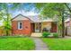 Charming brick home with manicured lawn, sidewalk, covered front porch, and decorative pink flamingo lawn decor at 752 N Leland Ave, Indianapolis, IN 46219