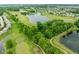 Aerial view of a community with a golf course, serene lakes, and tree-lined streets winding through well-kept homes at 7559 Pipestone Dr, Indianapolis, IN 46217
