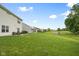 Large backyard featuring a pond, lush green lawn, mature trees, and a patio with outdoor seating for relaxing outdoors at 7559 Pipestone Dr, Indianapolis, IN 46217