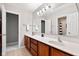 Bright bathroom with double vanity and sink, light fixtures, large mirror and view of tub/shower area at 7559 Pipestone Dr, Indianapolis, IN 46217
