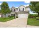 Charming two-story home with a well-manicured lawn and attached two-car garage at 7559 Pipestone Dr, Indianapolis, IN 46217