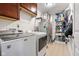 Functional laundry room with washer, dryer, and storage shelves for efficient home management at 7559 Pipestone Dr, Indianapolis, IN 46217