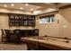 Entertainment basement with a bar area featuring stools with horseshoe logos and pool table at 7601 W Stonegate Dr, Zionsville, IN 46077