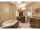 Bathroom featuring a jacuzzi tub, wood cabinets with granite counters, and tile flooring at 7601 W Stonegate Dr, Zionsville, IN 46077
