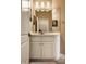 Charming powder room featuring a white vanity with beadboard detailing and decorative artwork at 7601 W Stonegate Dr, Zionsville, IN 46077