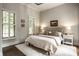 Bright bedroom featuring neutral decor, plantation shutters and hardwood floors at 7601 W Stonegate Dr, Zionsville, IN 46077