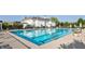 A pristine community pool with clear blue water, surrounded by lounge chairs and a beautifully landscaped area at 7601 W Stonegate Dr, Zionsville, IN 46077