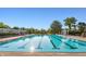 An inviting community pool area featuring clear blue water, lounge chairs, and a peaceful setting with lush greenery at 7601 W Stonegate Dr, Zionsville, IN 46077