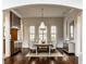 Dining room with dark wood floors, a large table, and shuttered windows for natural light at 7601 W Stonegate Dr, Zionsville, IN 46077