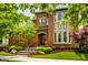 Stately brick home with manicured landscaping, a stone staircase, and a covered front entry at 7601 W Stonegate Dr, Zionsville, IN 46077
