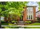 Charming brick home with manicured landscaping and inviting front entrance with stone steps and a black door at 7601 W Stonegate Dr, Zionsville, IN 46077