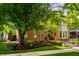 Beautiful brick home with lush landscaping, mature trees, and a welcoming front entrance at 7601 W Stonegate Dr, Zionsville, IN 46077