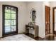 Welcoming foyer with a stylish console table, an oval mirror, and elegant hardwood floors, and a view to outdoors at 7601 W Stonegate Dr, Zionsville, IN 46077