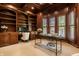 Stately home office features custom built-ins, wood paneled walls and plush carpet at 7601 W Stonegate Dr, Zionsville, IN 46077