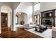 Bright living room featuring hardwood floors, high ceilings, fireplace, and arched doorways at 7601 W Stonegate Dr, Zionsville, IN 46077
