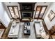 Aerial view of a living room with hardwood floors, fireplace, and double doors leading to the outside at 7601 W Stonegate Dr, Zionsville, IN 46077