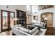 Inviting living room with a fireplace, stylish decor, hardwood floors, and French doors leading to an outdoor patio at 7601 W Stonegate Dr, Zionsville, IN 46077
