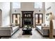 Cozy living room with a fireplace, hardwood floors, designer lamps, and a neutral color palette creating a relaxing ambiance at 7601 W Stonegate Dr, Zionsville, IN 46077