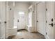 Mud room featuring white trim, built-in storage benches, coat hooks, and a tiled floor at 7601 W Stonegate Dr, Zionsville, IN 46077