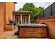 Outdoor patio featuring a stone hot tub, built-in grill, and a covered seating area with columns at 7601 W Stonegate Dr, Zionsville, IN 46077