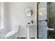 Modern bathroom with a pedestal sink, round decorative mirror and a glass-enclosed shower at 8100 N Meridian St, Indianapolis, IN 46260