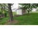 Fenced backyard featuring a shed, fire pit, and mature tree at 8160 Whitham Dr, Indianapolis, IN 46237