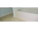 Clean white bathtub with chrome fixtures and easy to clean vinyl flooring at 8160 Whitham Dr, Indianapolis, IN 46237
