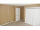 Bedroom featuring neutral carpet, tan walls, and a closet with white doors for ample storage at 8160 Whitham Dr, Indianapolis, IN 46237