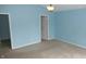 A light blue bedroom with neutral carpet and two doors at 8160 Whitham Dr, Indianapolis, IN 46237