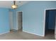 A light blue bedroom with neutral carpet and multiple doors at 8160 Whitham Dr, Indianapolis, IN 46237
