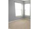 Bedroom featuring gray walls, carpet, and a corner of windows with views of the neighborhood at 8160 Whitham Dr, Indianapolis, IN 46237