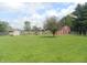 Expansive backyard with lush green grass, mature trees, a shed, and a barn provides ample space at 833 N 700 W, Greenfield, IN 46140