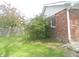 Lush green lawn next to a brick home with mature tree and garden at 833 N 700 W, Greenfield, IN 46140