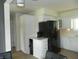 Well-lit kitchen with white cabinetry, stainless steel refrigerator, and hardwood flooring at 833 N 700 W, Greenfield, IN 46140