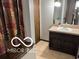 Bathroom with a vanity, sink, and decorative mirror near the stairway at 8835 Winding Ridge Rd, Indianapolis, IN 46217