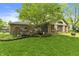 Backyard view of the home's sunroom and deck surrounded by green grass at 8909 Ellington Dr, Indianapolis, IN 46234