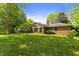 Lush backyard featuring well-maintained lawn, mature trees, and house exterior at 8909 Ellington Dr, Indianapolis, IN 46234