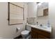Neutral bathroom featuring a wood vanity, toilet, and framed mirror at 8909 Ellington Dr, Indianapolis, IN 46234