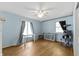 Bright bedroom featuring hardwood floors, a ceiling fan, and natural light streaming through the windows at 8909 Ellington Dr, Indianapolis, IN 46234