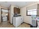 Cozy laundry room with vintage washer/dryer combo and neutral walls with decorative trim at 8909 Ellington Dr, Indianapolis, IN 46234