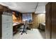 Basement office with a corner desk, wood paneling, and built-in shelving at 8909 Ellington Dr, Indianapolis, IN 46234