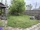 Wide backyard featuring a central tree, wooden fence, and patio area with chairs, creating a private outdoor space at 909 Sullivan St, Alexandria, IN 46001