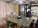 Eclectic dining room with a unique, large green table, floral wallpaper, and open access to the adjacent living space at 909 Sullivan St, Alexandria, IN 46001
