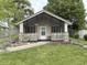 Charming home featuring a cozy front porch with stone accents and a white picket fence at 909 Sullivan St, Alexandria, IN 46001