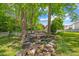 Backyard oasis featuring a tranquil pond and stone patio with fire pit, surrounded by mature trees for ultimate privacy at 10172 Watkins Ct, Indianapolis, IN 46234